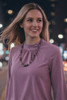 Model wearing Lavender and Sage 22-inch amethyst necklace styled with light purple blouse, showing natural drape and scale.