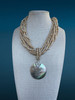 One-of-a-kind coastal necklace featuring multi-strand coconut shell heshi beads with a large iridescent mother-of-pearl shell pendant from the Stone & Story Vintage Curated Collection.