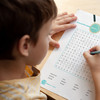 Over the shoulder view of a child working on a word find puzzle