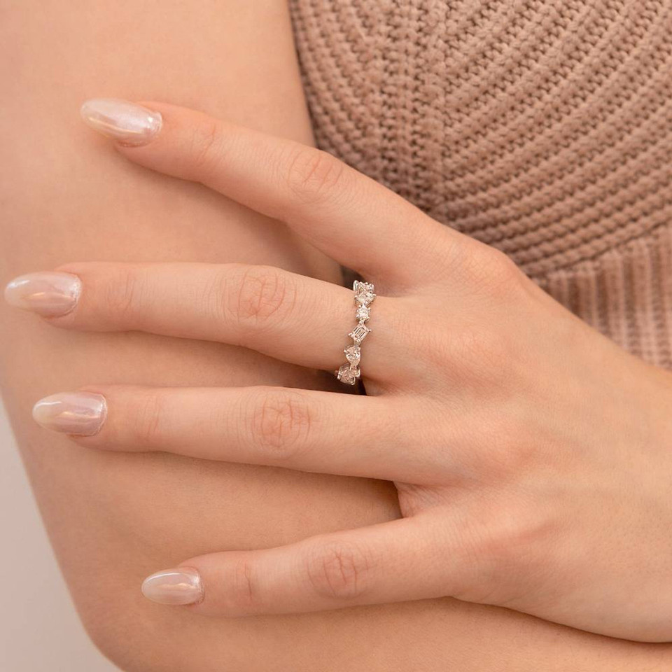 Hand holding an arm while wearing a mix-cut diamond ring