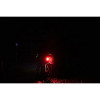 LED Rear Light 30 Lumen attached to a bike turned on in a dark environment viewed from the back