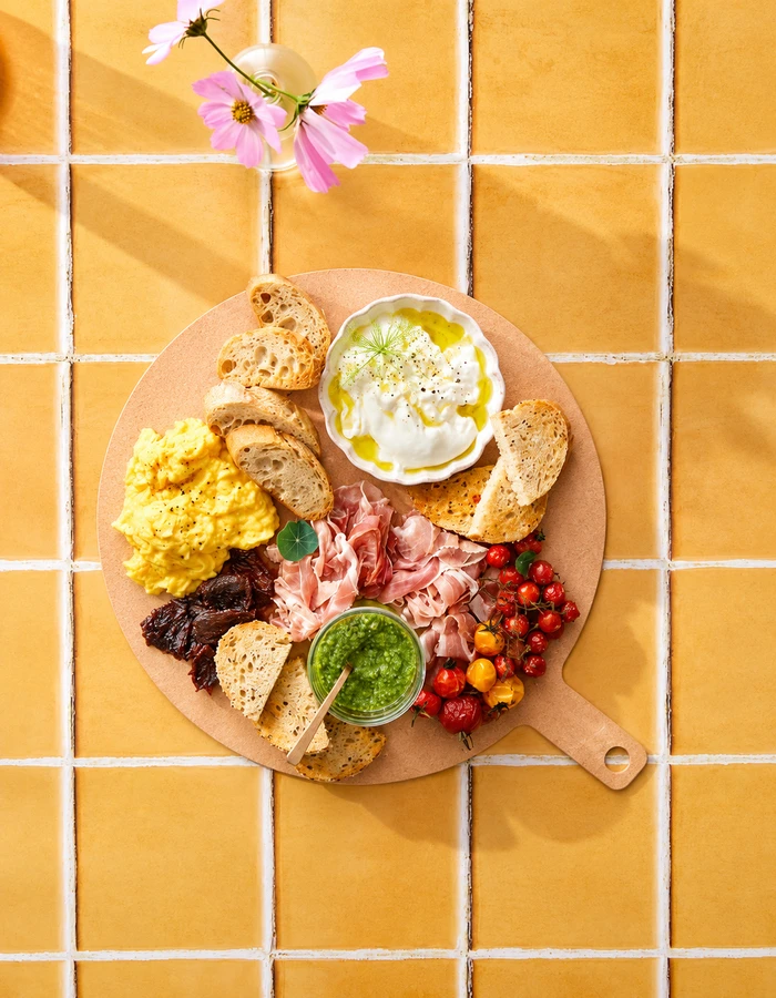 Round wooden tray with a charcuterie spread