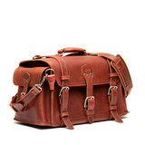 High quality red brown side pocket duffle from the front. Made from full grain leather (toughest there is) and reinforced with rivets on any stress points. Made by Saddleback Leather