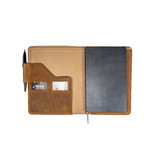 Opened and filled tobacco colored leather journal cover with a closed journal, pen, and cards. Made by Saddleback