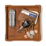 High quality tan colored leather valet tray with a wallet, keys, change, and a pocket knife on it. Made by Saddleback