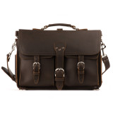 High quality straight on picture of a red brown leather briefcase that is 17 inches wide and has two front pockets on it with a flap over them.