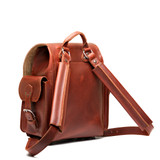 High quality red brown full grain leather baby tank backpack from the back. Has 2 shoulder pads and a handle for easy carry. Made by Saddleback