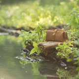 High quality tan brown leather toiletry bag by water.