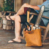 High quality tan brown women's leather tote that some women use as a purse. It is facing the side.