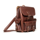 High quality red brown leather backpack with three pockets on the outside. The image of this backpack is the front side.
