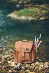 High quality the back picture of the tan brown leather backpack with fireworks in the side pocket.