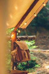 High quality this light brown leather backpack is hanging from a pole.