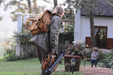 High quality a woman photographer is wearing a leather backpack  in Africa and her son is running towards her.