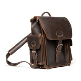 High quality squared dark brown leather backpack with an old phone behind the side pocket.