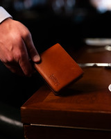 This is the lifestyle view of the William Penn Bifold Wallet in tan