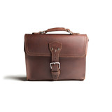 High quality front side of a red brown leather satchel with a front pocket.