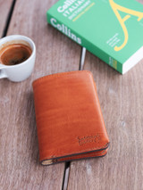 This is the closed lifestyle image of the passport sleeve in tan