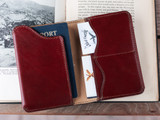 High quality open lifestyle image of the passport leather sleeve in reddish brown