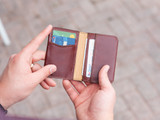 High quality lifestyle image of the Silverback Slim Bifold leather Wallet in reddish brown