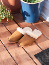 High quality lifestyle image of the light tan sheepskn slippers