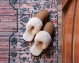 High quality lifestyle image of the womens light tan sheepskin slippers