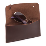 High quality red brown leather wallet bag wide open with sunglasses.
