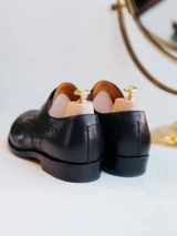 High quality black full grain leather wing tip shoes rear three-quarter view showing heel counter and back seam - Saddleback Leather