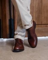 High quality dark oak full grain leather toe cap shoes front view with ankles crossed showing brogue detail - Saddleback Leather
