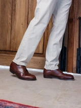 High quality dark oak full grain leather toe cap shoes side profile walking on stone floor - Saddleback Leather