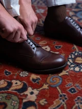 High quality close-up of dark oak full grain leather toe cap shoe lacing and brogue perforation detail - Saddleback Leather