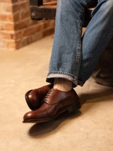 High quality overhead close-up of dark oak full grain leather toe cap shoe brogue detail and vamp - Saddleback Leather
