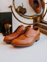 High quality tan full grain leather toe cap shoes studio three-quarter front view with brass vanity mirror - Saddleback Leather