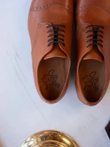 High quality tan full grain leather toe cap shoes overhead close-up of lacing and embossed leather insoles - Saddleback Leather