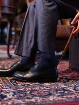 High quality black full grain leather toe cap shoe side view with long shoe horn next to vintage trunk - Saddleback Leather