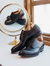 High quality black full grain leather toe cap shoes studio side profile with shoe tree and mirror reflection - Saddleback Leather