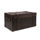 High quality leather trunk that will be a vintage antique one day in a museum. This is the back of the luggage with rivets and leather for a hinge. It is a dark brown steamer trunk that was old time luggage back in the day on trains and ships.