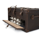 High quality leather trunk that will be a vintage antique one day in a museum. This is the front door of it that is open and angled. It is a dark brown steamer trunk that was old time luggage back in the day on trains and ships.