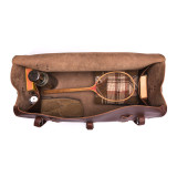 High quality this leather duffle bag is red brown and has three straps on it . It is showing the inside.