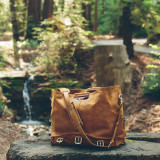 High quality tan brown leather duffle bag being used as a tote with it wide open.