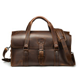 High quality red brown leather duffle bag that has three straps to close it and has two round handles from the front straight on.