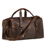 High quality dark brown leather duffle bag that has three straps to close it and has two round handles from the front.