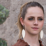 model image of the white leather feather earrings