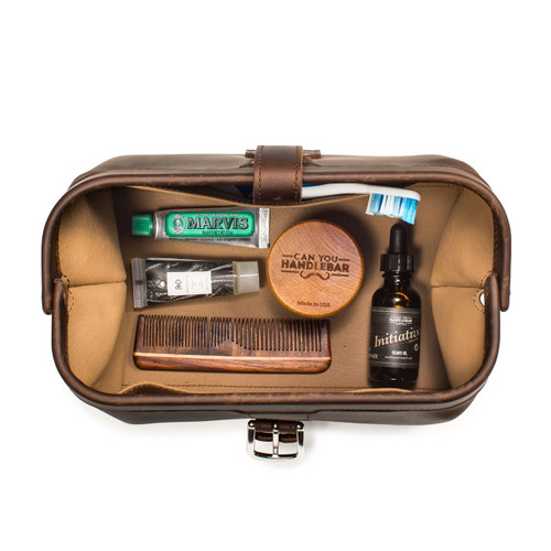 High quality dark brown leather toiletry bag on the opened and loaded.
