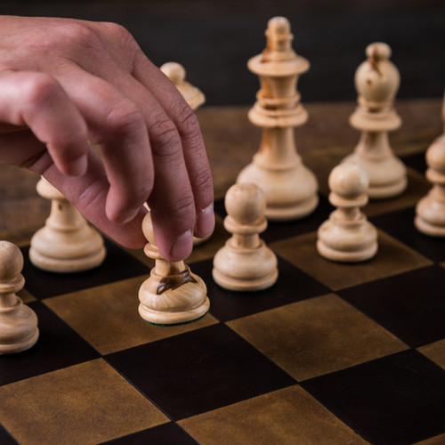 High quality these are chess pieces being moved on a leather travel chess set.