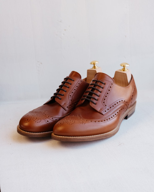 High quality red brown full grain leather wing tip shoes studio three-quarter front view with wooden shoe trees - Saddleback Leather