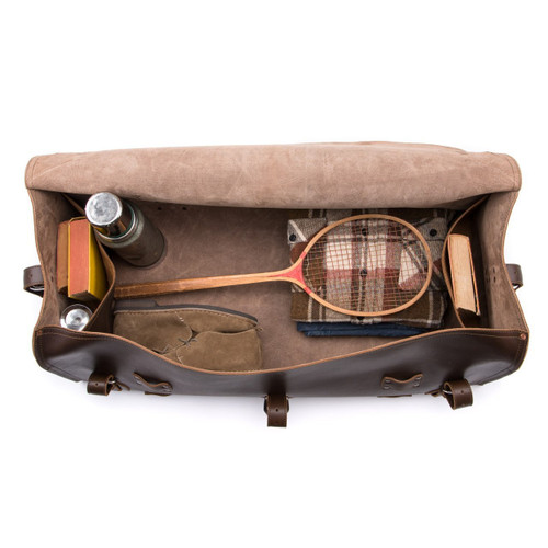 High quality this leather duffle bag is dark brown and has three straps on it . It is showing the inside.