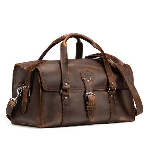 This is a dark brown leather duffle bag that has three straps to close it and has two round handles from the front side.