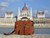 This is a red brown full grain leather briefcase in front of parliament in Budapest, Hungary.