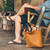 This is a tan brown women's leather tote that some women use as a purse. It is facing the side.