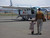 High quality the back picture of the tan brown leather backpack on a woman's back as her toddler son is running towards her in Africa.